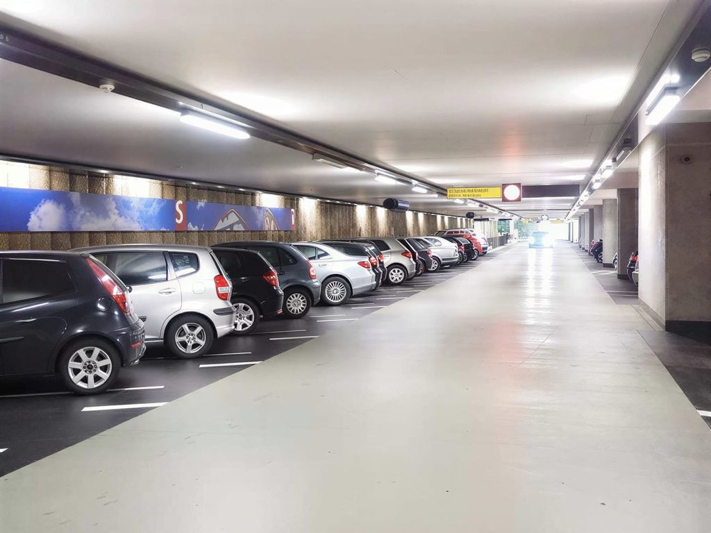 Jasno oświetlony parking kryty z miejscami postojowymi