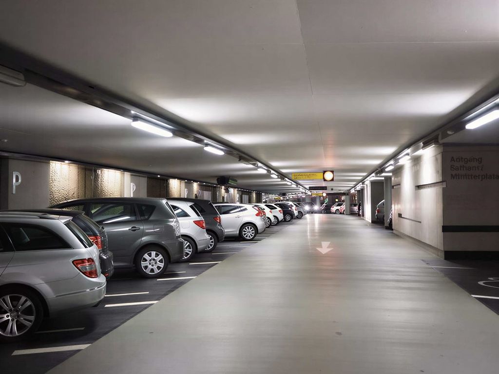 Zadaszony parking podziemny z rzędami zaparkowanych samochodów